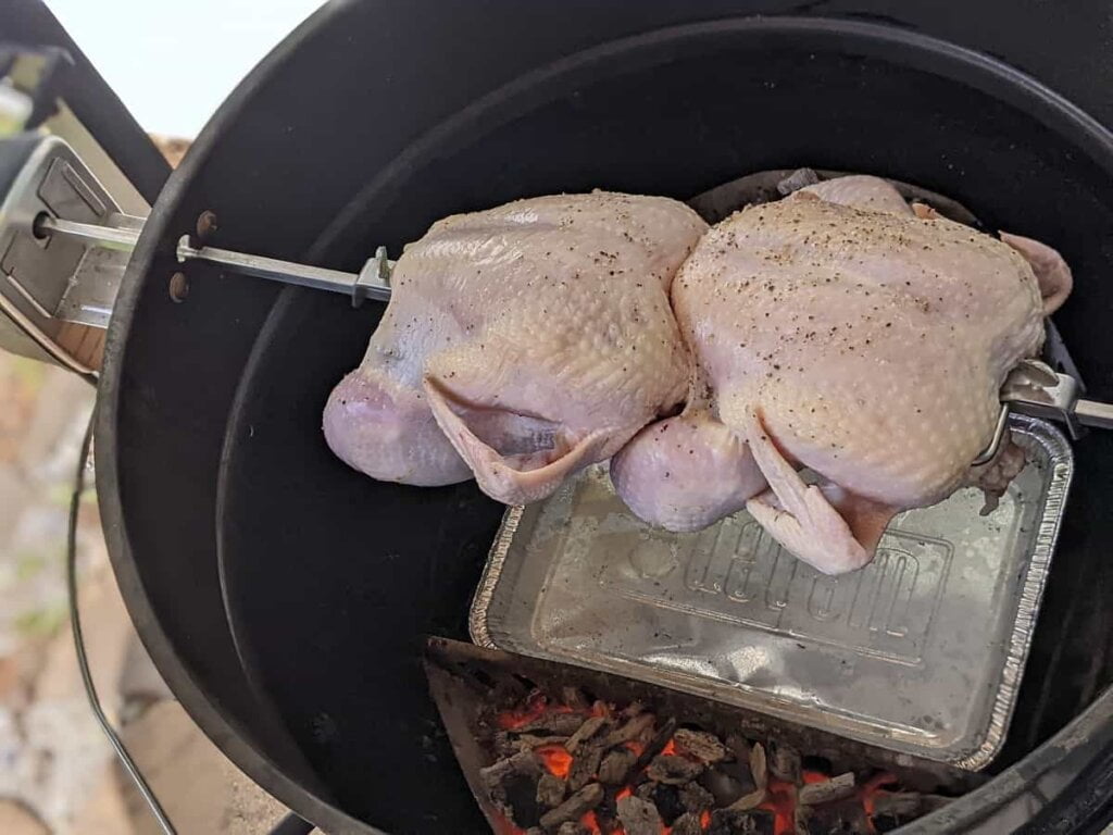 rotisserie cooking chickens on charcoal grill indirect heat