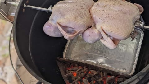 rotisserie cooking chickens on charcoal grill indirect heat