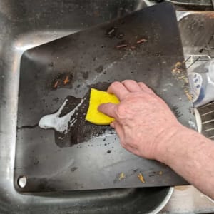 scrubbing pizza steel using dish detergent and water