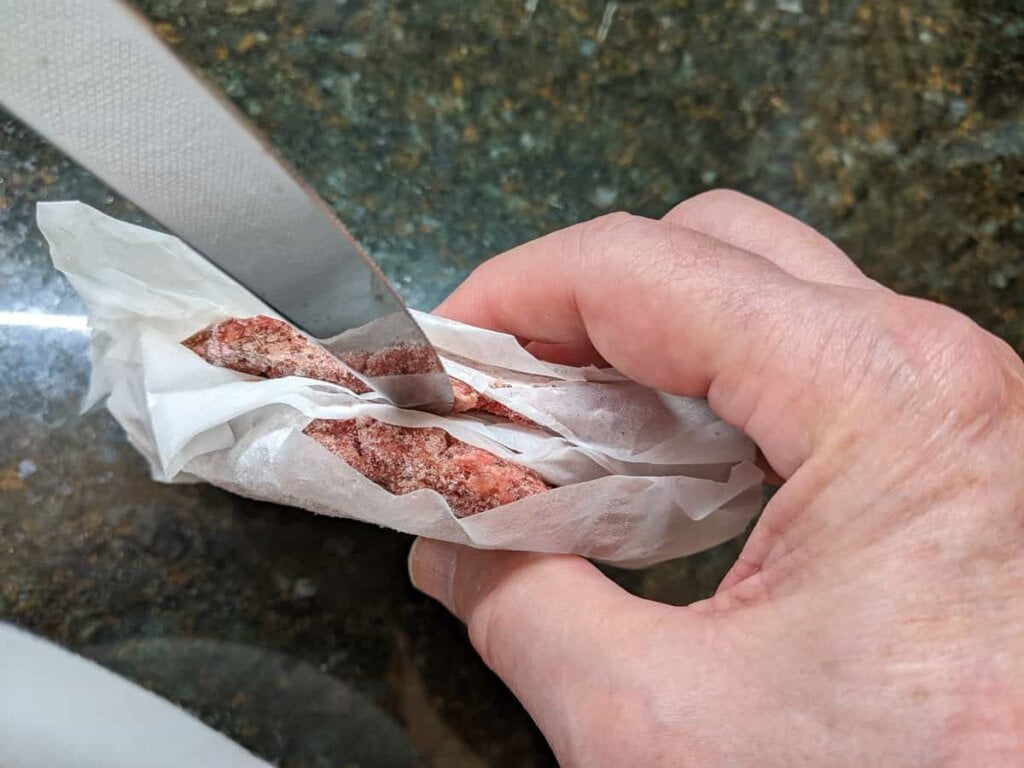 separating patties to cook frozen burgers on grill