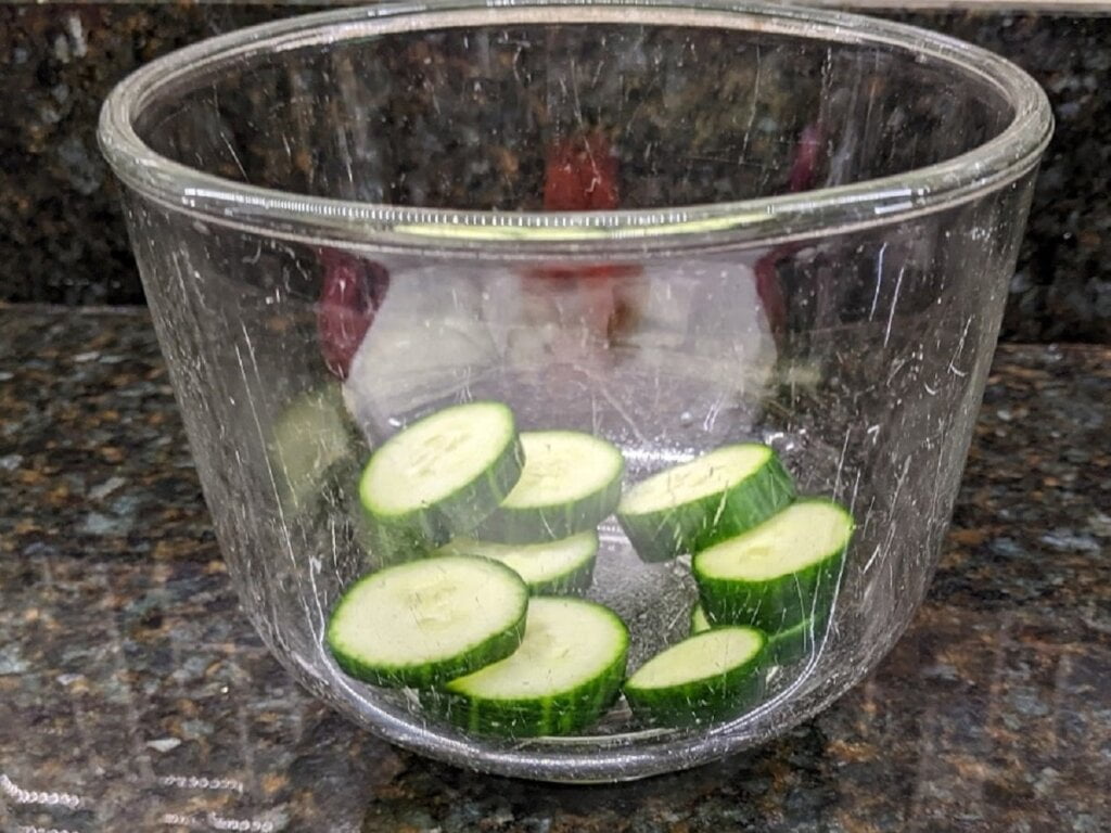 Sliced cucumber in salad bowl for cucumber tomato salad with ranch dressing