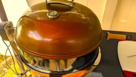 slow roasting in covered weber grill with rotisserie