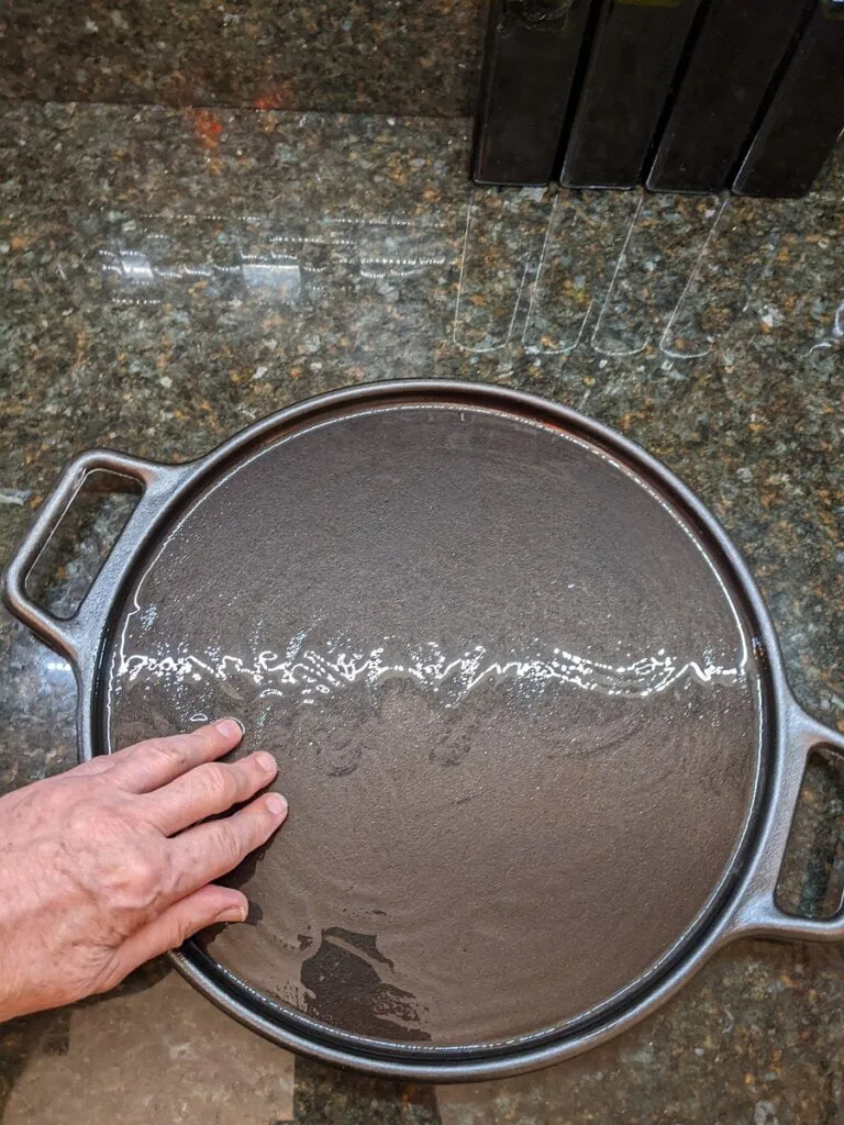 Spreading out the olive oil coating on the pizza cast iron pan