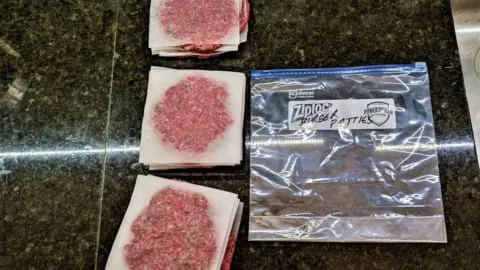 stacked burger patties inserted into marked food bag for freezing