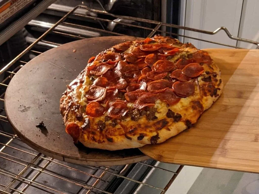 transferring pizza from oven using wooden peel