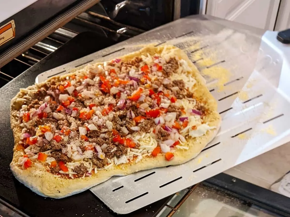 transferring pizza to oven using a metal peel