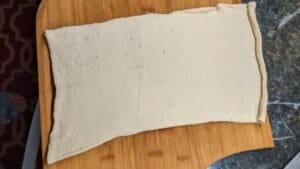unroll the crescent roll dough for making pigs in a blanket recipe