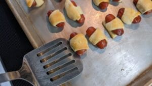 use spatula to remove pigs in a blanket from baking sheet