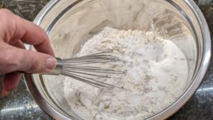 using whisk to combine all ingredients of pancake mix from scratch recipe