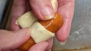 wrapping a little smokie in crescent dough triangle for recipe